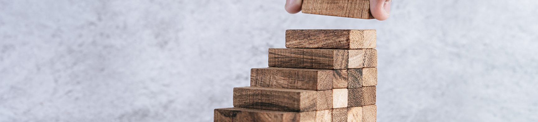 Stacking wooden blocks is at risk in creating business growth ideas.